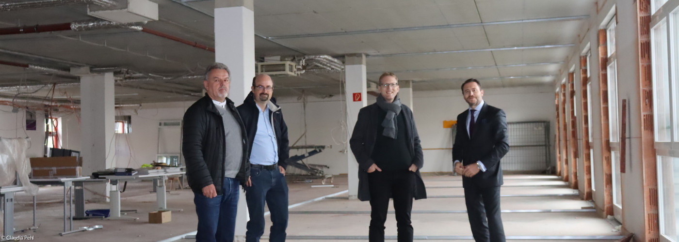 Hermann Schuch (Präsidium), Stefan Wirth (Leiter Verwaltungsstelle) und Dekan Max von Egidy lassen sich vom Eigentümer Sebastian Kulig (Kulig Gruppe) durch die Baustelle in der Ringstraße führen.